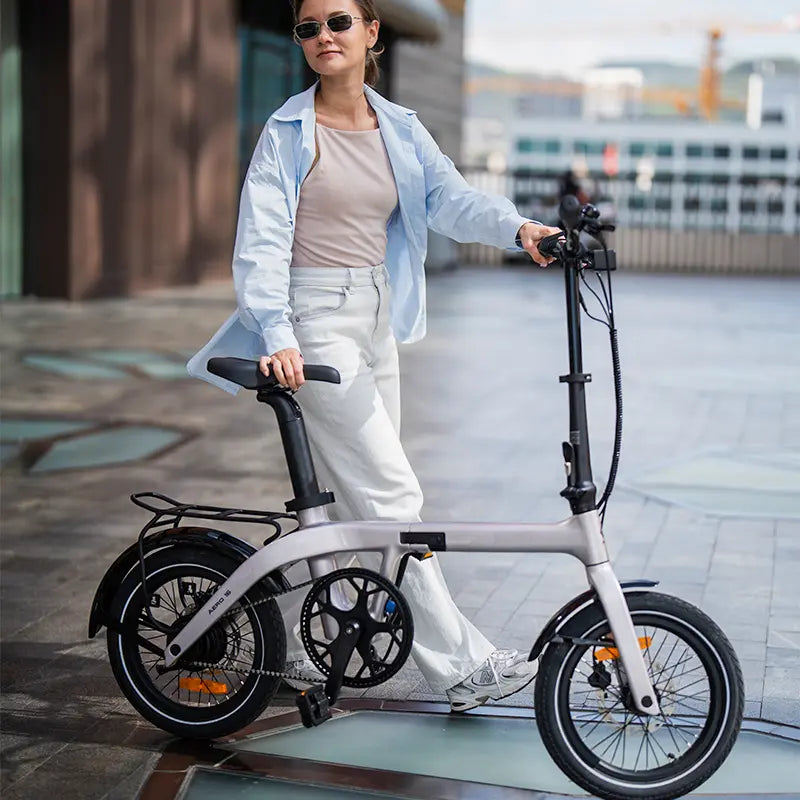 Woman pushing a carbon fiber folding electric bike on a city street